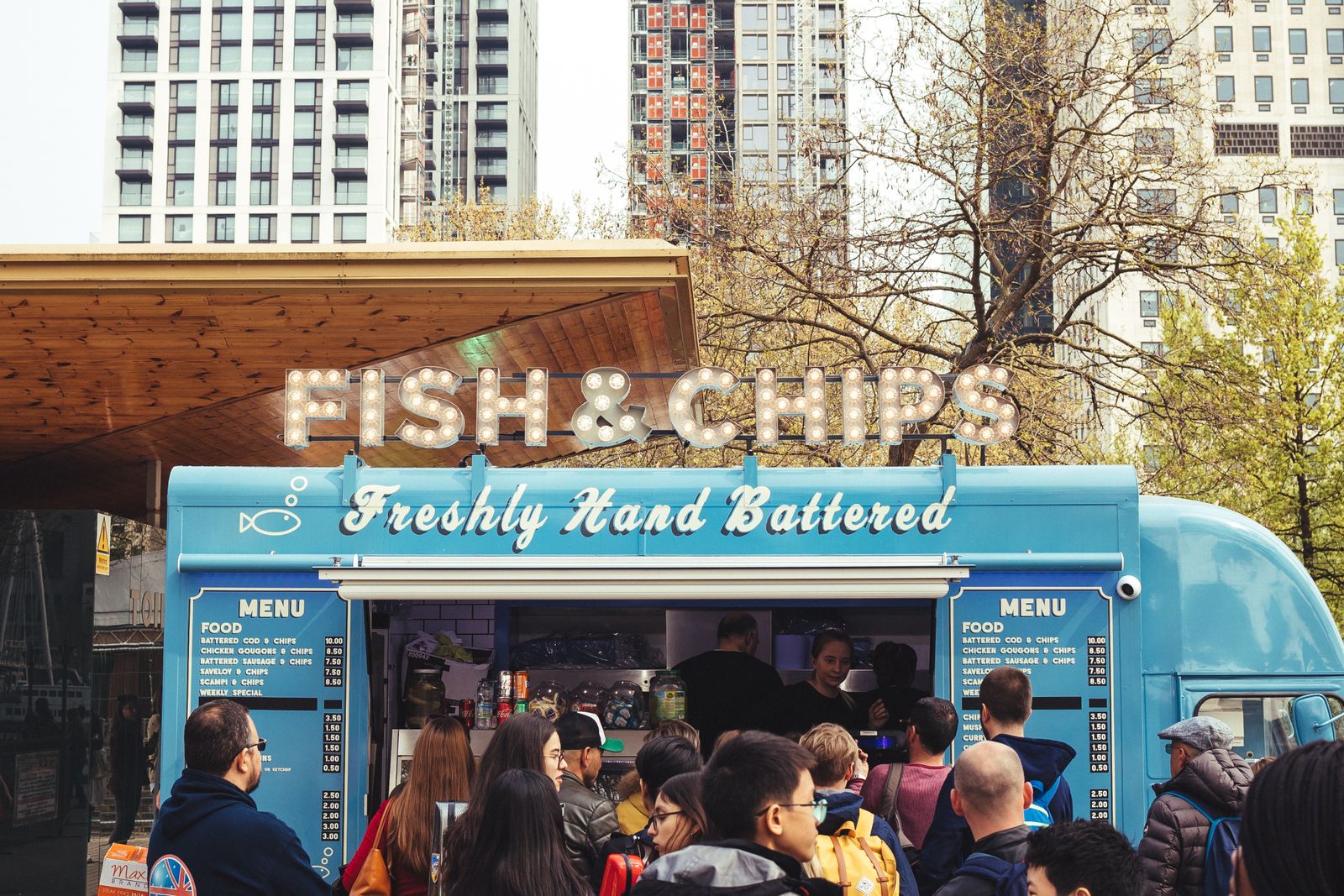 Fish and chips van serving a queue of customers on a London street